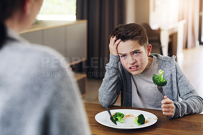 Buy stock photo Disgust, food and child with vegetables in home for nutrition, health and cooking. Lunch, angry and dinner with boy and refuse to eat broccoli at tablet for eating problem, frustrated and dislike