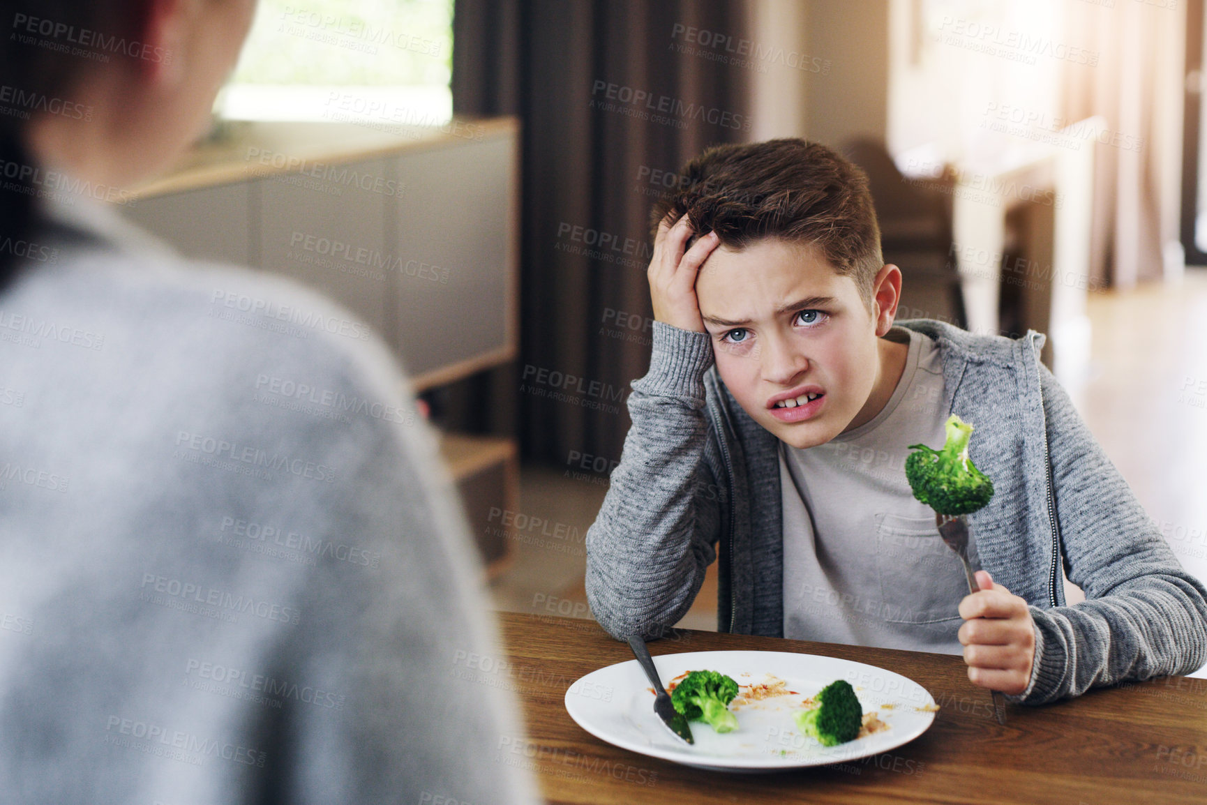 Buy stock photo Disgust, food and child with vegetables in home for nutrition, health and cooking. Lunch, angry and dinner with boy and refuse to eat broccoli at tablet for eating problem, frustrated and dislike