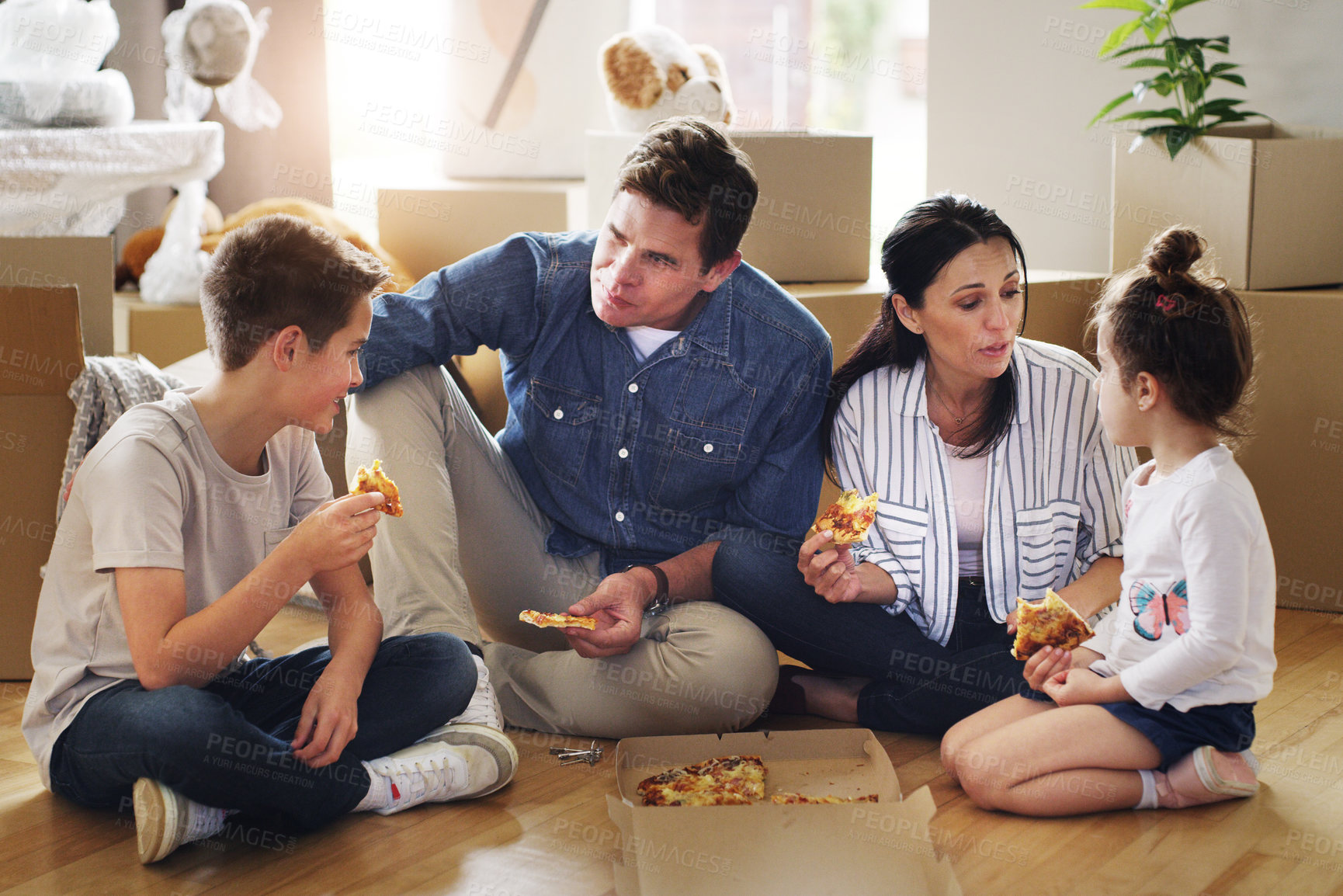 Buy stock photo Parents, children and pizza or moving boxes in new home for unpacking break, fast food or bonding. Mother, father and siblings eating of floor or real estate purchase for mortgage, family or property