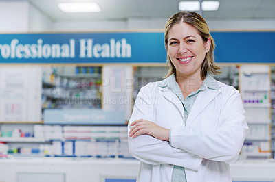 Buy stock photo Portrait of a young pharmacist smiling and posing with her arms folded in a pharmacy