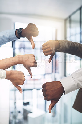 Buy stock photo Closeup shot of a group of businesspeople showing thumbs down in an office