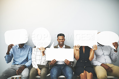 Buy stock photo Studio shot of a group of businesspeople holding speech bubbles in line against a gray background