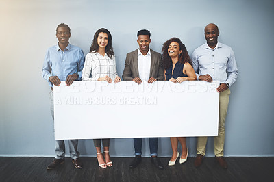 Buy stock photo Studio shot of a group of businesspeople holding a sign against a gray background