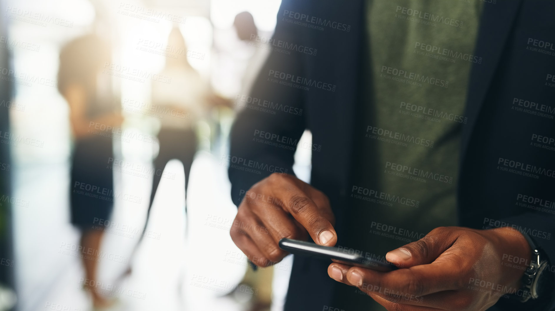 Buy stock photo Closeup shot of an unrecognizable businessman using a cellphone in an office with his colleagues in the background
