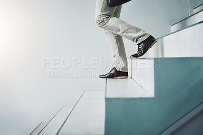 Buy stock photo Closeup shot of an unrecognizable businessman walking down a staircase in an office