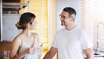 Buy stock photo Happy couple, talking and morning with coffee in kitchen for breakfast, chat or bonding at home. Man and woman with smile or drink for caffeine, conversation or weekend together in pajamas at house