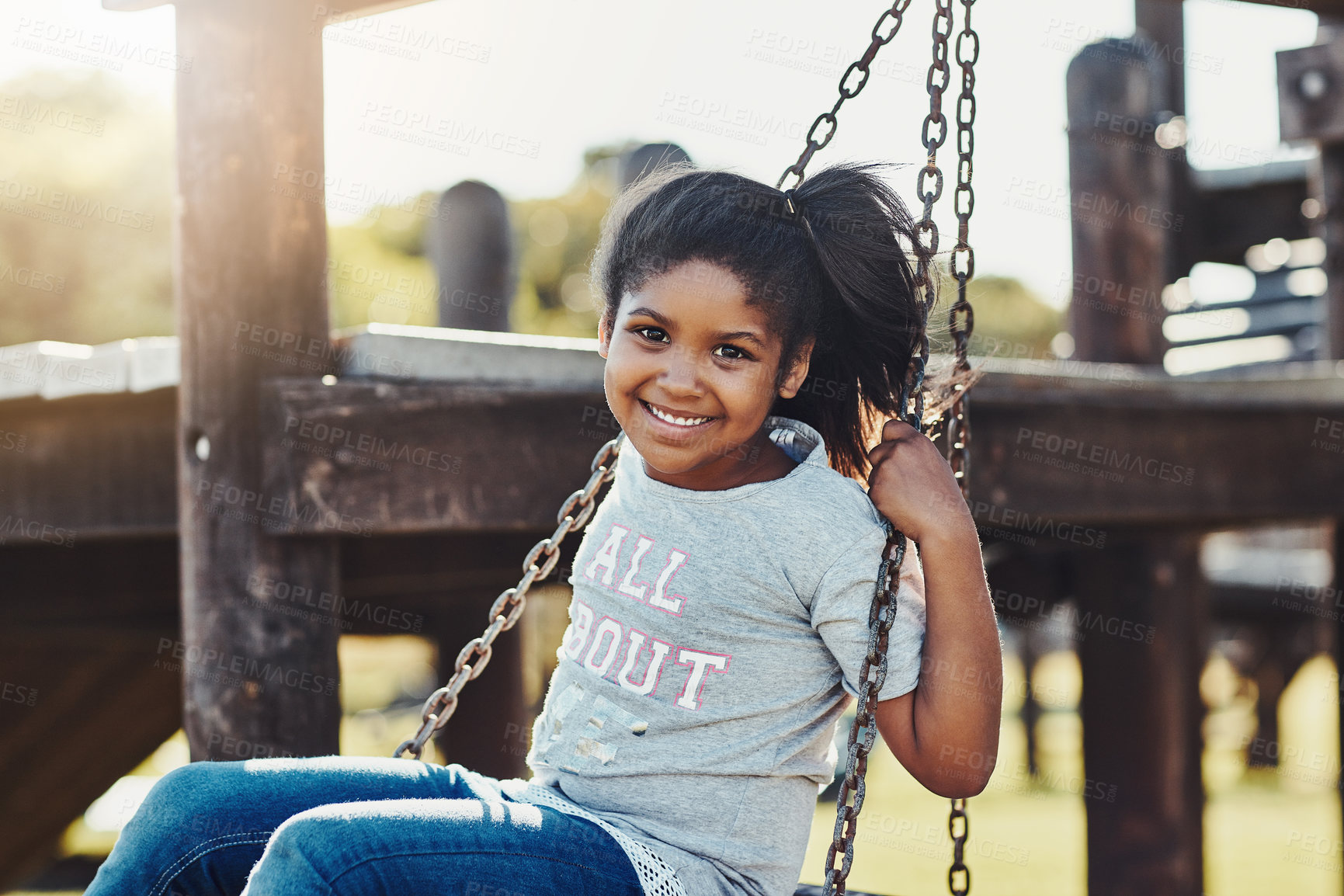 Buy stock photo Cropped portrait of an adorable little girl playing on a swing at the park