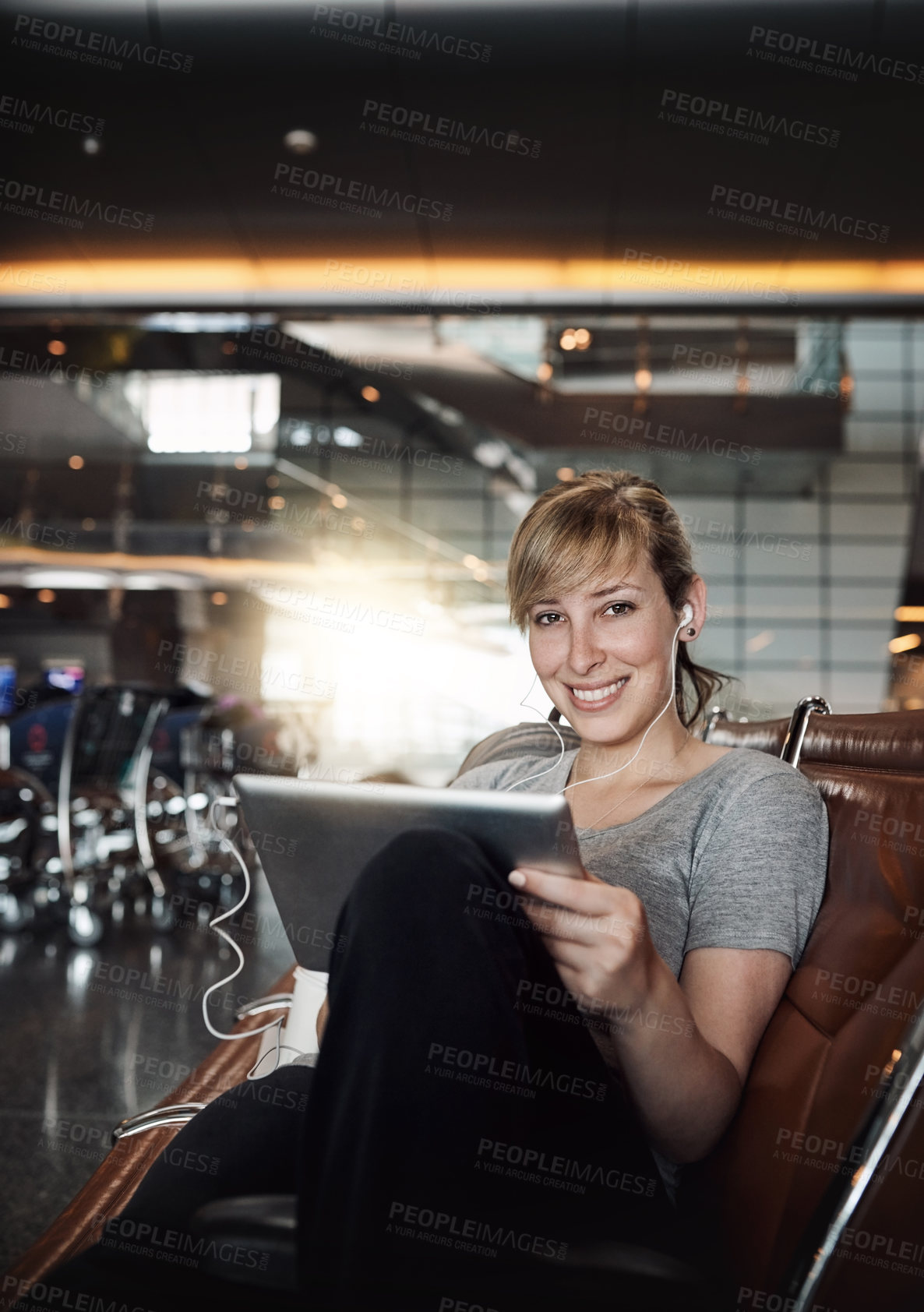 Buy stock photo Woman, airport and waiting with earphones on tablet for streaming music and online videos. Female person, tourist and portrait with smile in lobby on internet for social media and entertainment
