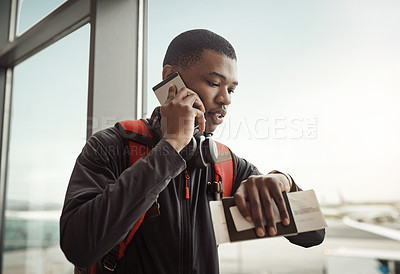 Buy stock photo Cropped shot of a handsome young man checking the time while making a call in an airport