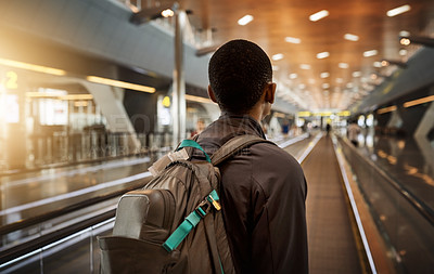 Buy stock photo Rearview shot of an unrecognizable young man standing on a moving walkway in the airport