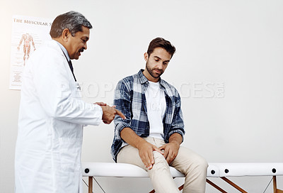 Buy stock photo Healthcare, doctor and patient with knee pain in consultation for expert advice, information and discussion. Medicine, health care and Indian man in doctors office consulting medical professional.