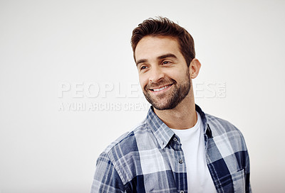 Buy stock photo Studio shot of a cheerful young man standing against a white background while looking directly at the camera
