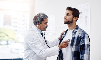 Buy stock photo Healthcare, patient and doctor with stethoscope for checkup, help and wellness at hospital. Medicine, health care and heart expert with Indian man in doctors office consulting medical professional.