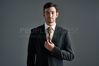 Buy stock photo Studio portrait of a young businessman with a noose tied around his neck for a tie against a gray background