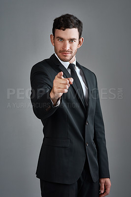 Buy stock photo Studio portrait of a young businessman pointing at you against a gray background