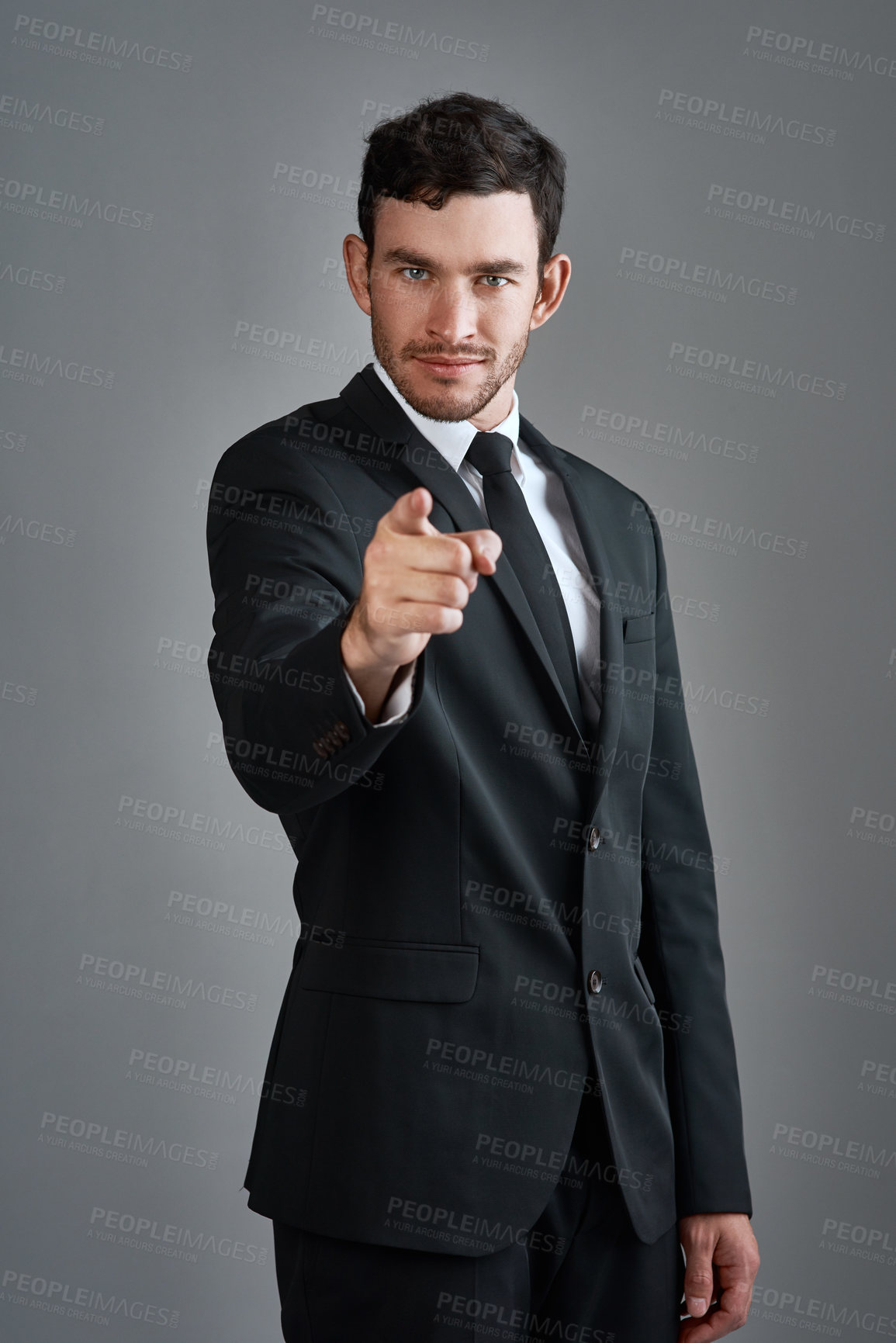 Buy stock photo Studio portrait of a young businessman pointing at you against a gray background