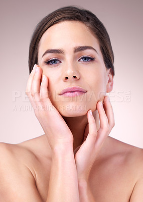Buy stock photo Studio portrait of a beautiful young woman touching the soft skin on her face against a pink background