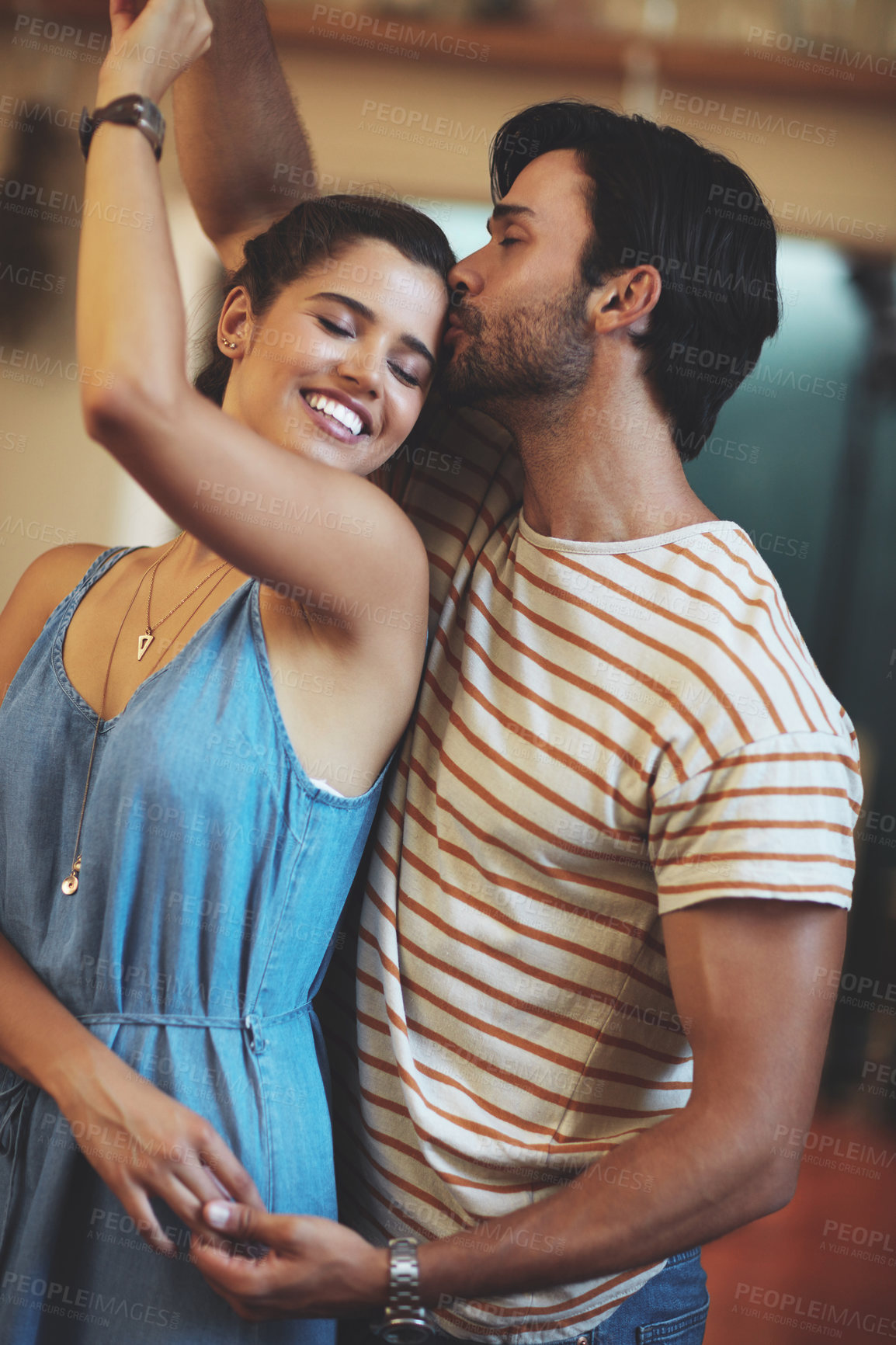 Buy stock photo Happy, couple and kiss with dancing in home for romantic bonding, connection and love in marriage. Man, woman and smile with holding hands in living room for anniversary, loyalty and care on weekend