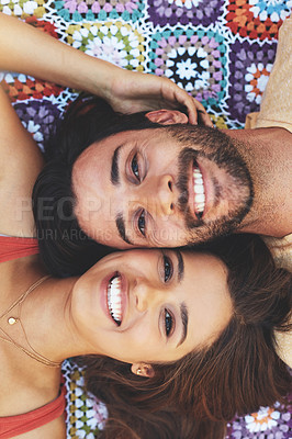 Buy stock photo High angle portrait of a happy young couple relaxing on a blanket outside