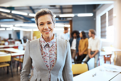 Buy stock photo Cropped portrait of an attractive mature businesswoman in the office with his colleagues in the background