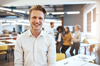 Buy stock photo Cropped portrait of a handsome young businessman in the office with his colleagues in the background