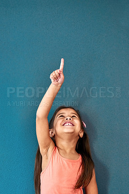 Buy stock photo Pointing up, happy and child in studio with mockup space for omg news, opinion and feedback. Emoji, surprise and isolated, excited and girl with announcement, information and deal on blue background