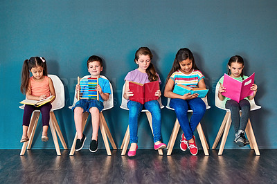 Buy stock photo Kids, studying and row with books in studio for learning, development and knowledge for test. Chair, students and children reading with paper for school education, scholarship and academic growth