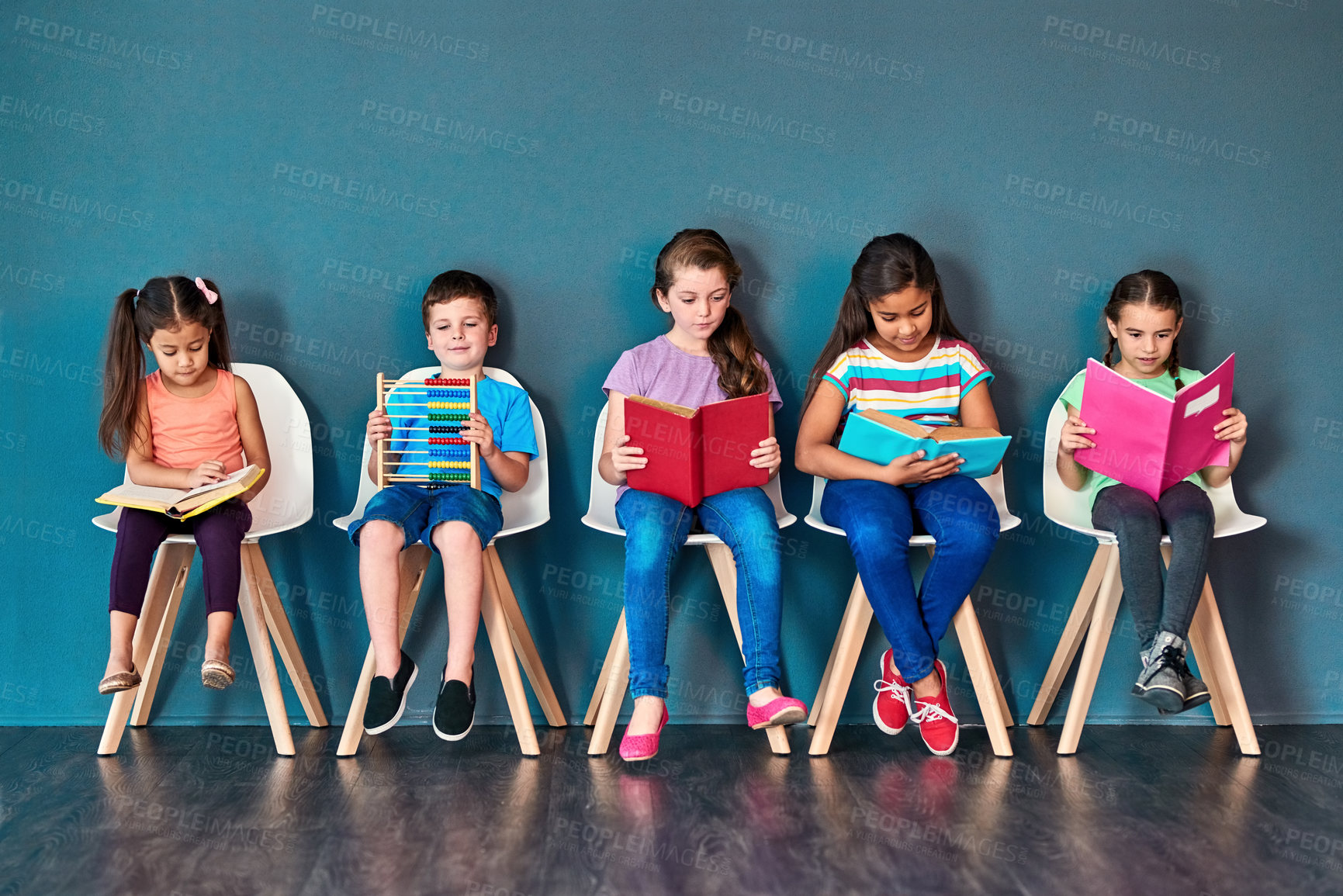 Buy stock photo Kids, studying and row with books in studio for learning, development and knowledge for test. Chair, students and children reading with paper for school education, scholarship and academic growth