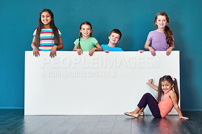 Buy stock photo Children, happy and marketing in studio for placard, advertising and portrait with mockup space. People, promotion and logo on blue background for banner, branding and announcement with information