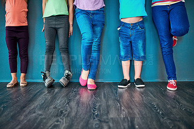 Buy stock photo Fashion, row and legs of children in studio for trendy outfit, causal clothes and style. Diversity, youth and shoes of boys and girls for back to school, education and learning on wall background