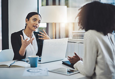 Buy stock photo Shot of two businesswomen having a discussion in an office