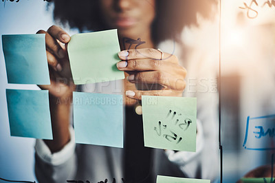 Buy stock photo Closeup shot of a businesswoman brainstorming notes on a glass wall in an office