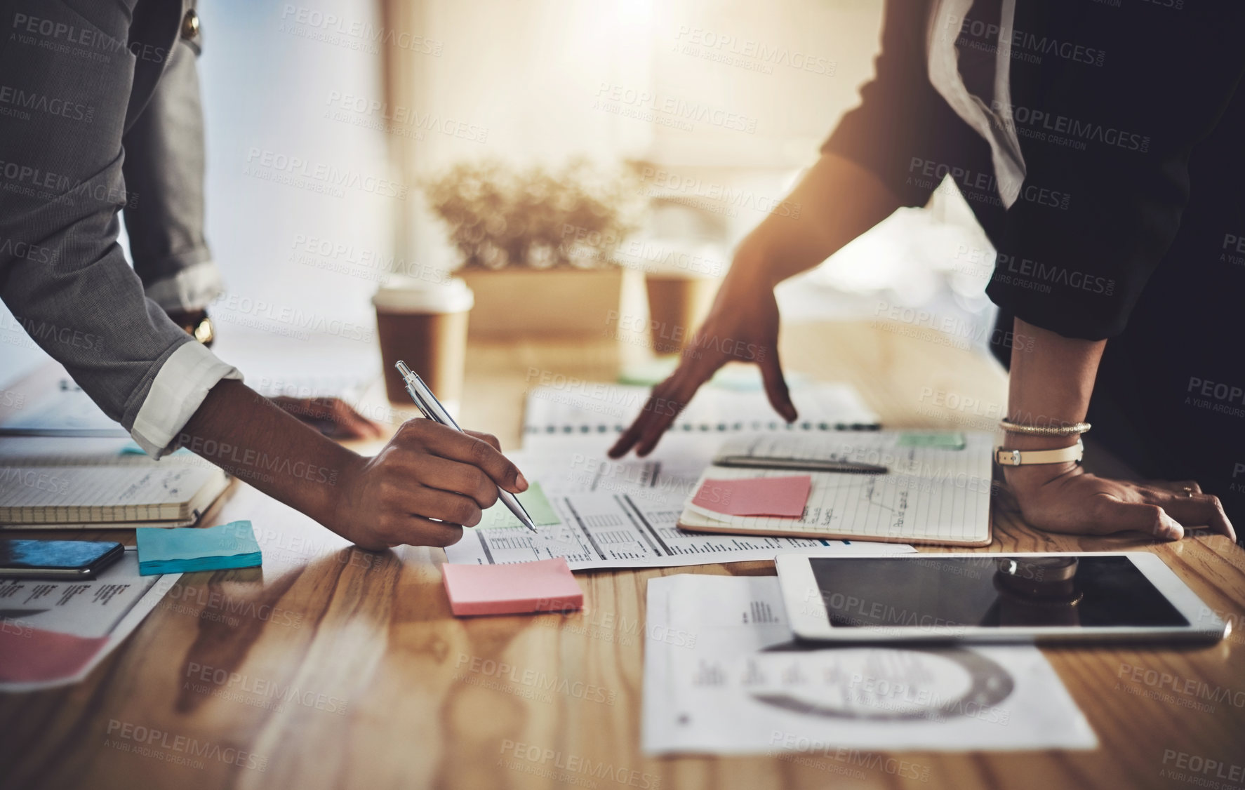 Buy stock photo Closeup shot of two businesswomen going through paperwork in an office