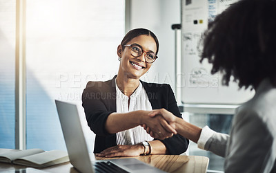 Buy stock photo Shot of two businesswomen shaking hands in an office