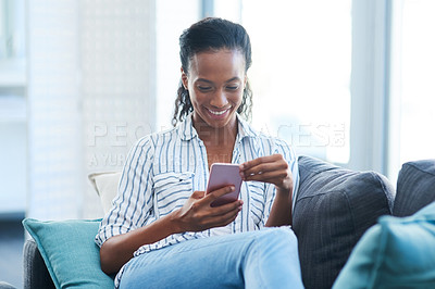 Buy stock photo Shot of a young woman texting on a cellphone at home