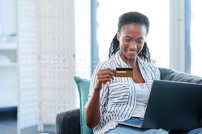 Buy stock photo Shot of a young woman using a credit card and laptop at home
