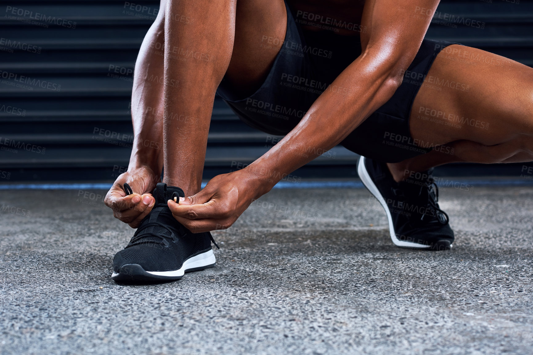 Buy stock photo Shot of an unrecognizable man tying his shoelaces in the middle of his exercise routine