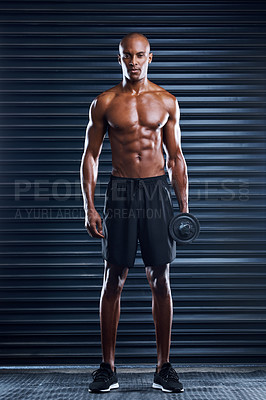 Buy stock photo Shot of a sporty young man working out with weight plates as part of his exercise routine