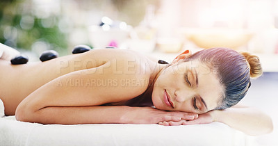 Buy stock photo Woman, relax and rock massage at spa sleeping for healthy wellness, skincare or stress relief at the resort. Calm female person relaxing in peaceful zen, hot stone back or body treatment at the salon