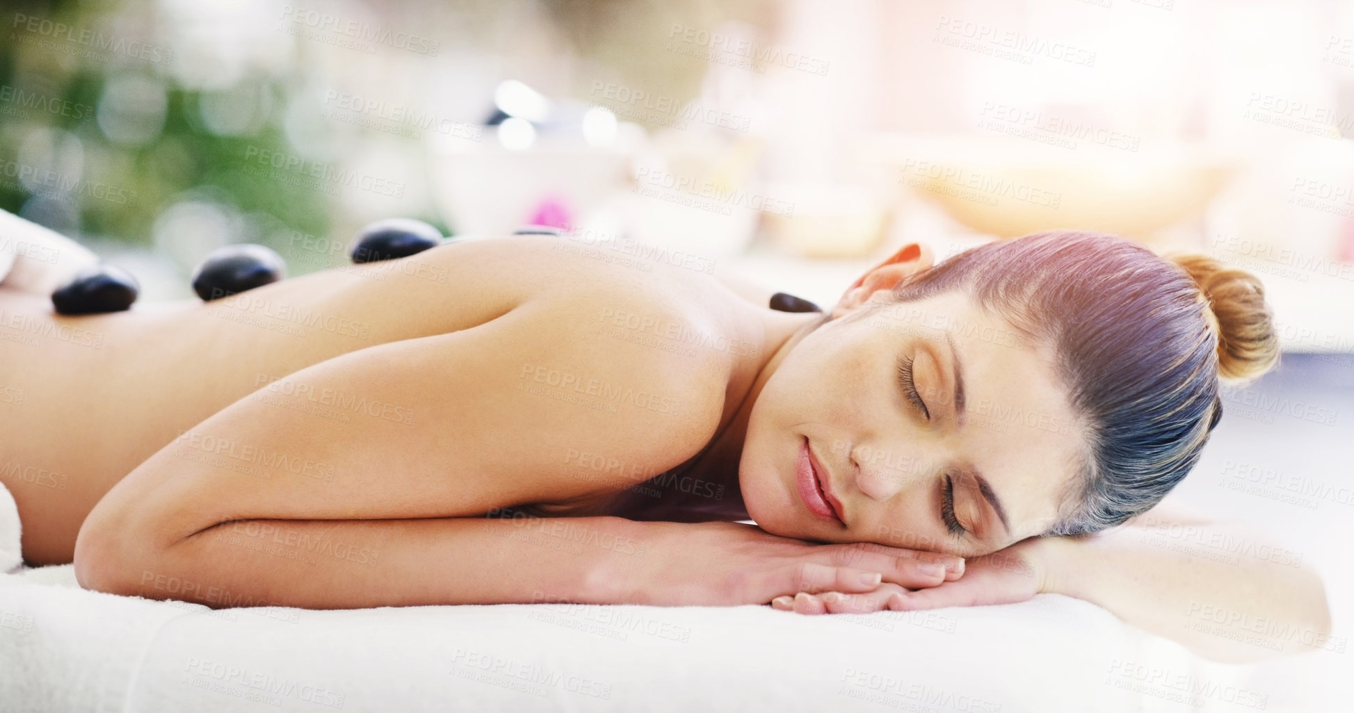 Buy stock photo Woman, relax and rock massage at spa sleeping for healthy wellness, skincare or stress relief at the resort. Calm female person relaxing in peaceful zen, hot stone back or body treatment at the salon