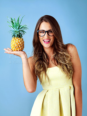 Buy stock photo Studio shot of a young woman holding a pineapple against a blue background