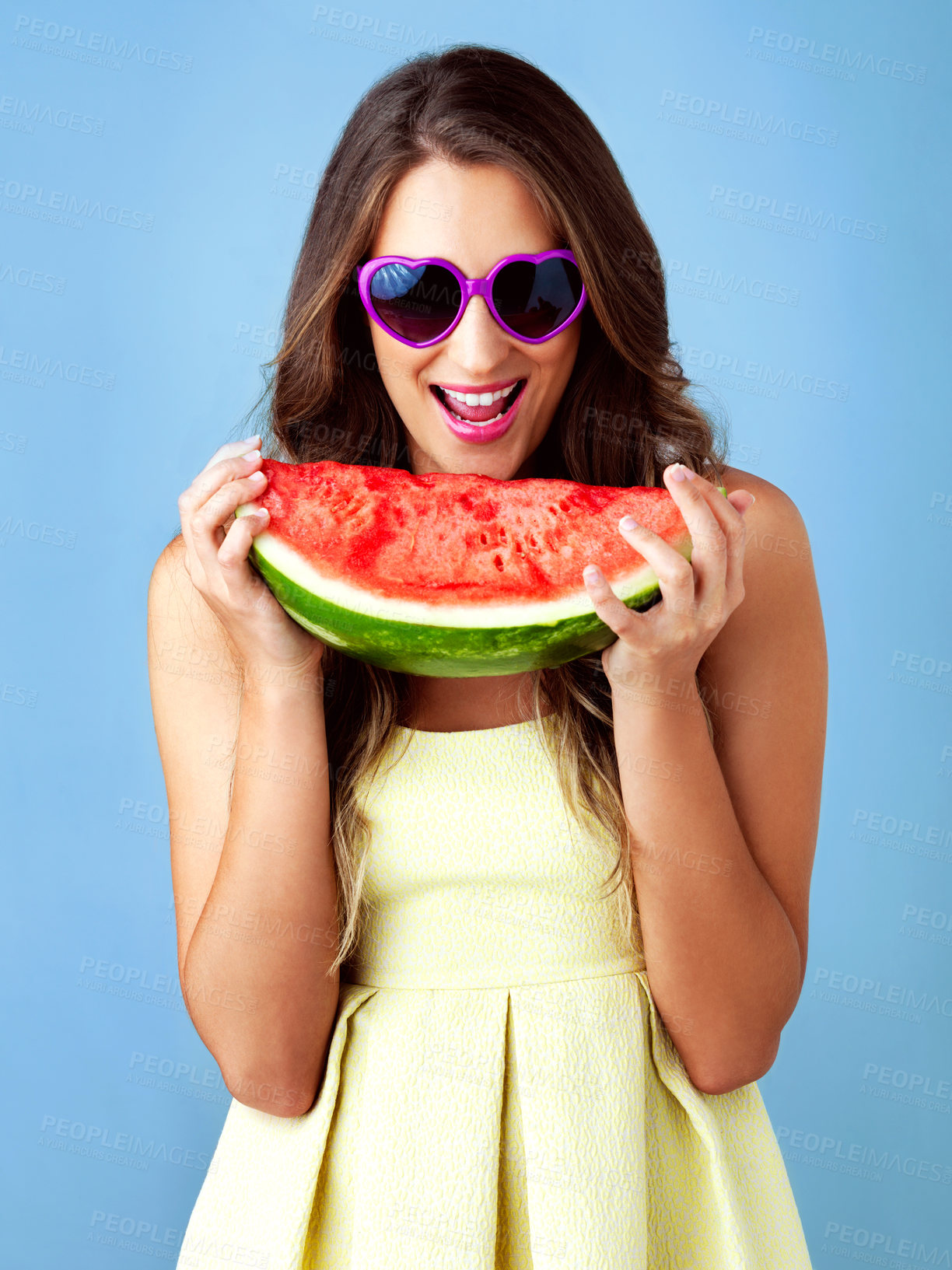 Buy stock photo Excited, woman and portrait with watermelon in studio for summer snack, confident or smile with nutrition. Gen z model, fruit and sunglasses on blue background for diet, vitamins or healthy food