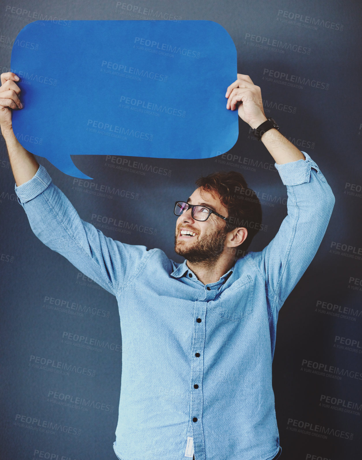 Buy stock photo Studio shot of a young man holding a speech bubble against a grey background