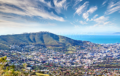 Buy stock photo Copy space with cloudy blue sky over the view of a coastal city seen from Signal Hill in Cape Town South Africa. Scenic panoramic landscape of buildings in an urban town along the mountain and sea