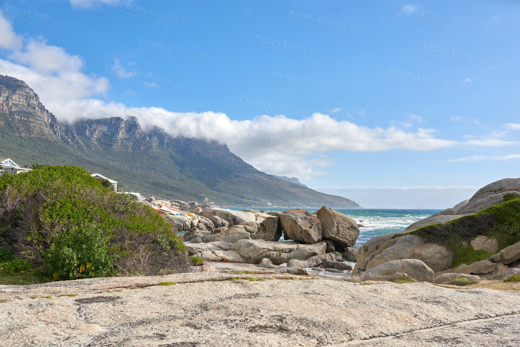 Buy stock photo Beautiful landscape of Camps Bay in Cape Town, South Africa. Scenic mountains and rocks near the ocean or sea with a blue sky background. Peaceful nature at the beach with seascape on a summer day 