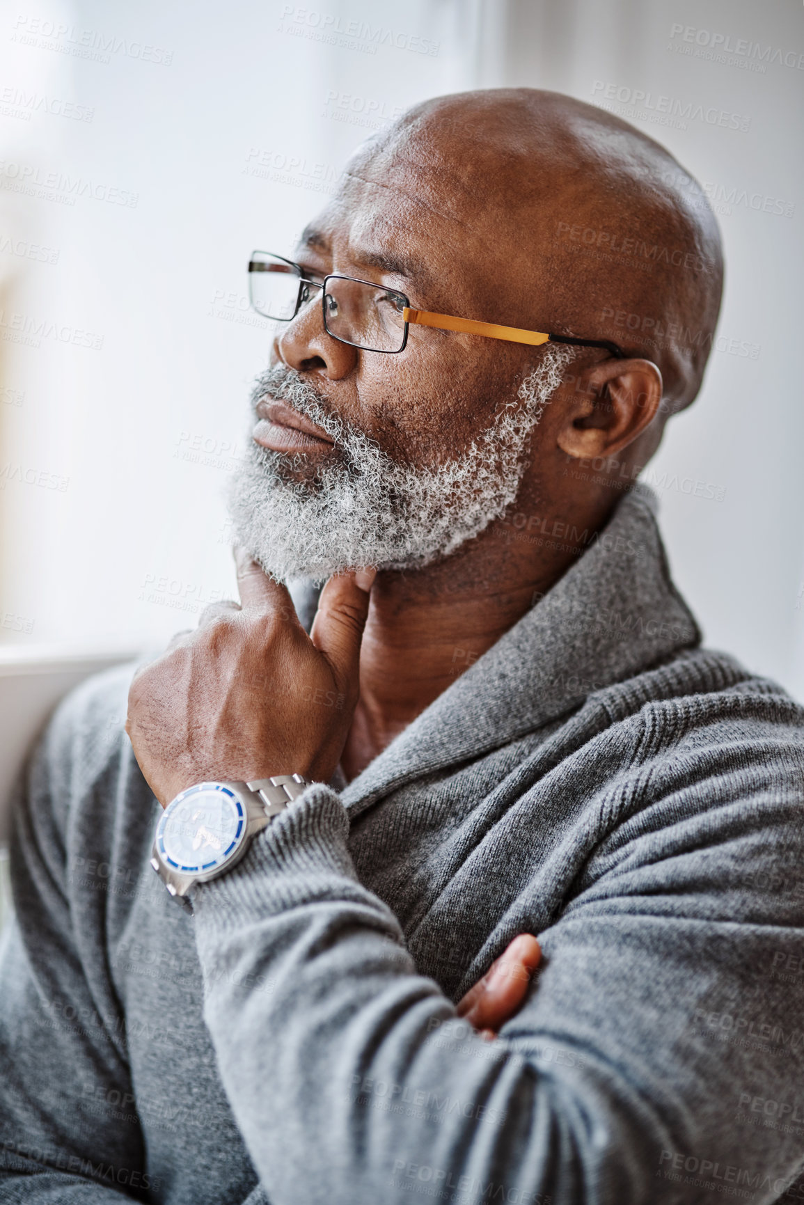 Buy stock photo Shot of a handsome senior man looking thoughtful while relaxing at home