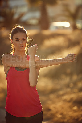 Buy stock photo Shot of a sporty young woman exercising outdoors