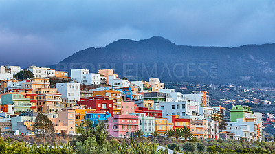 Buy stock photo Colorful buildings in Santa Cruz de La Palma with copy space. Beautiful cityscape with bright colors mountains and overcast clouds. A vibrant holiday or vacation destination on the hillside
