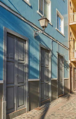 Buy stock photo Houses or homes built in vintage architecture design in a small town village. Vibrant city with cobble stone road or street. Blue building with grey doors in the streets of Santa Cruz de La Palma. 