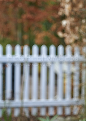 Buy stock photo A white classic fence surrounded by green lush plants and trees. Blurred barricade outdoors of a house in the backyard near the garden. Barrier of a home with vibrant flora on a summer day